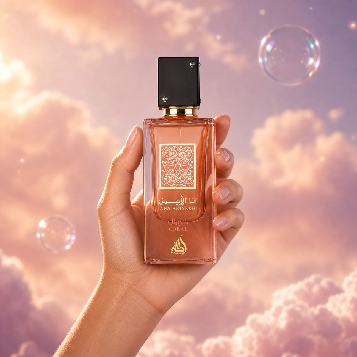 Una mano sostiene el frasco de Ana Abiyedh Coral de Lattafa entre nubes rosadas.