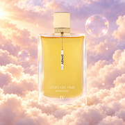 Frasco de Club de Nuit Précieux IV de Armaf sobre un banco de nubes, en un cielo rosa y lavanda con pompas iridiscentes y luz dorada.