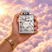 Una mano sostiene el frasco de Club de Nuit Sillage de Armaf entre nubes rosadas.