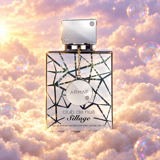 Frasco de Club de Nuit Sillage de Armaf sobre un banco de nubes, en un cielo rosa y lavanda con pompas iridiscentes y luz dorada.