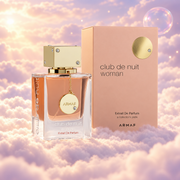 El frasco de Club de Nuit Woman Extrait de Parfum de Armaf junto a su caja original, sobre nubes.