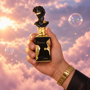 A hand holds the bottle of His Confession by Lattafa among pink clouds.