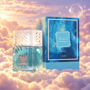 The bottle of Khamrah Waha by Lattafa next to its original box, on clouds.