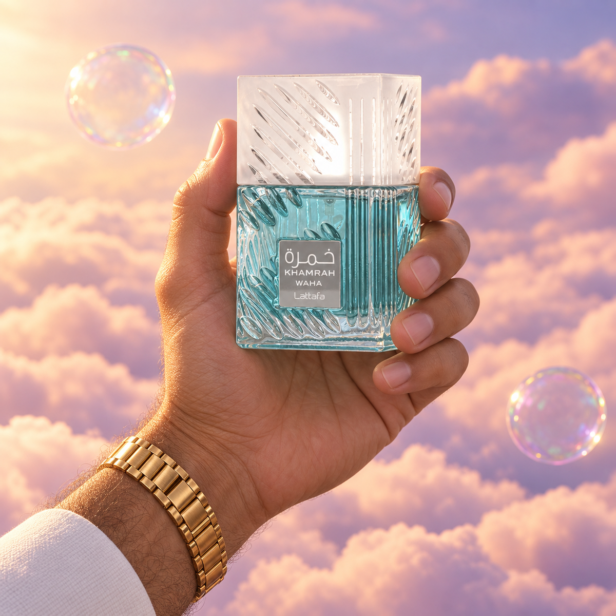 A hand holds the bottle of Khamrah Waha by Lattafa among pink clouds.