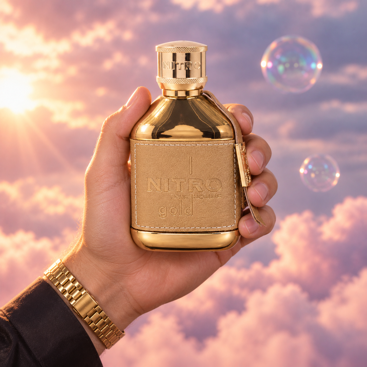 Una mano sostiene el frasco de Nitro Gold de Dumont entre nubes rosadas.