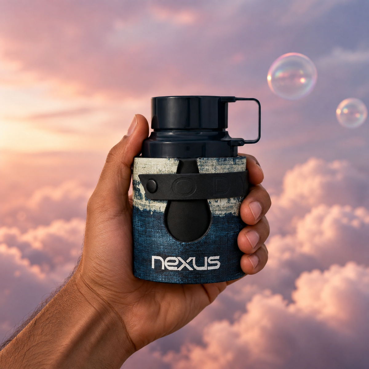 A hand holds the bottle of Odyssey Nexus by Armaf among pink clouds.
