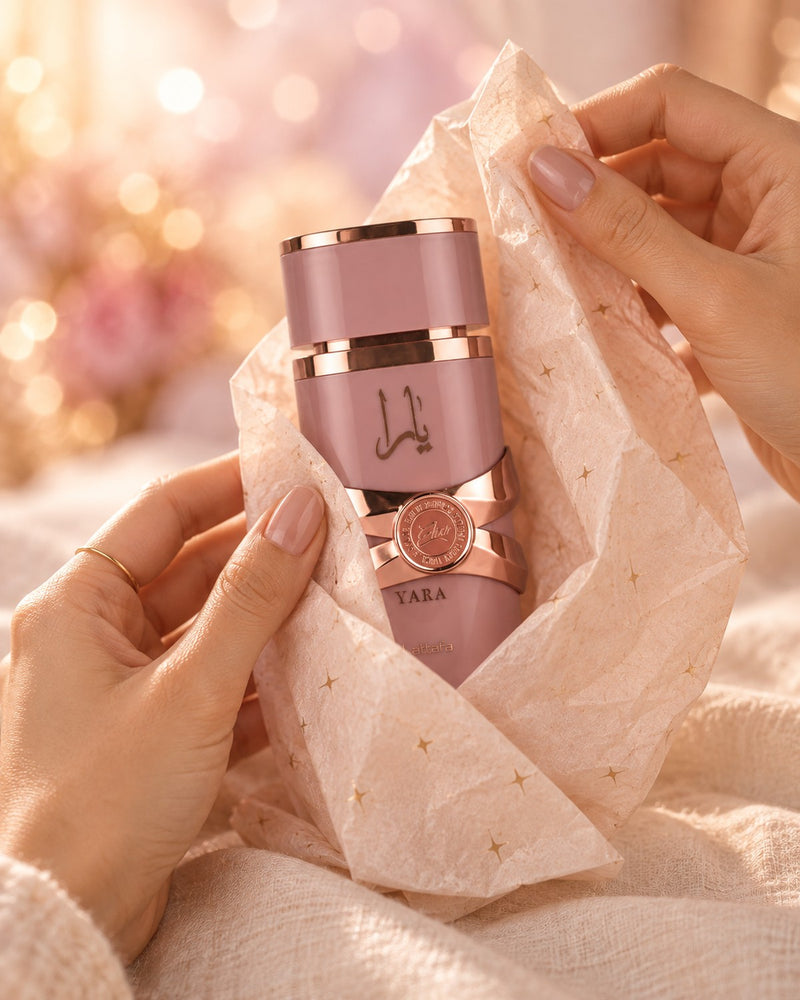 Unas manos envolviendo un perfume en papel de seda con estrellas