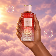A hand holds the bottle of Rome La Bomba by Bharara among pink clouds.